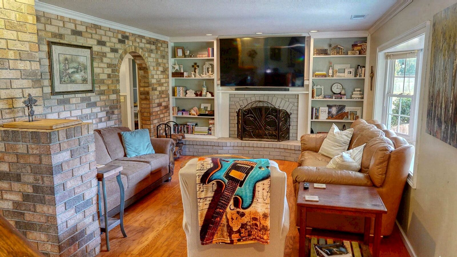 Living room with brick wood-burning fireplace and built-ins at 193 Grace Lane, Rincon GA