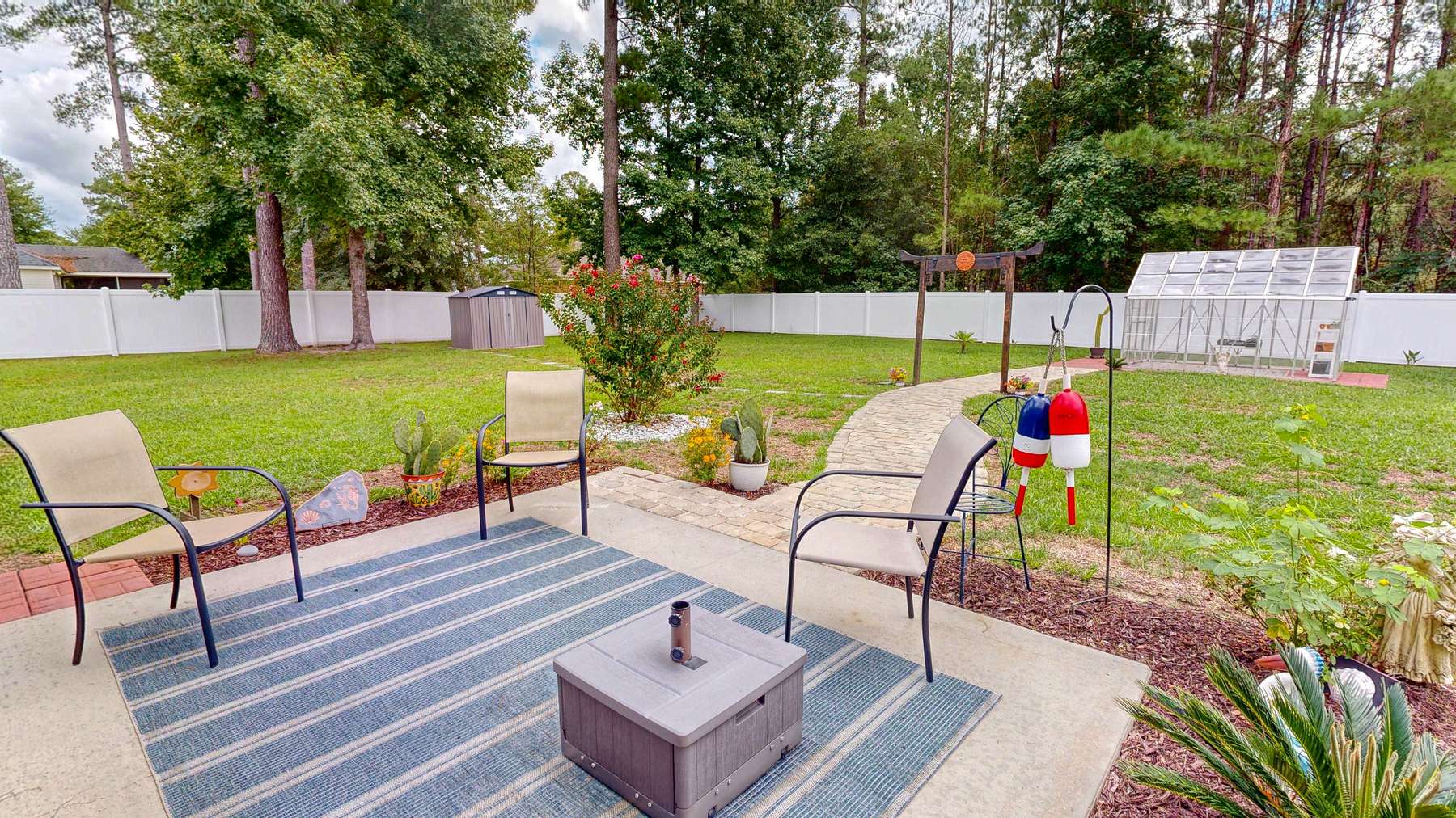 Open rear patio and curved paver walkway behind this Brooklet GA home for sale