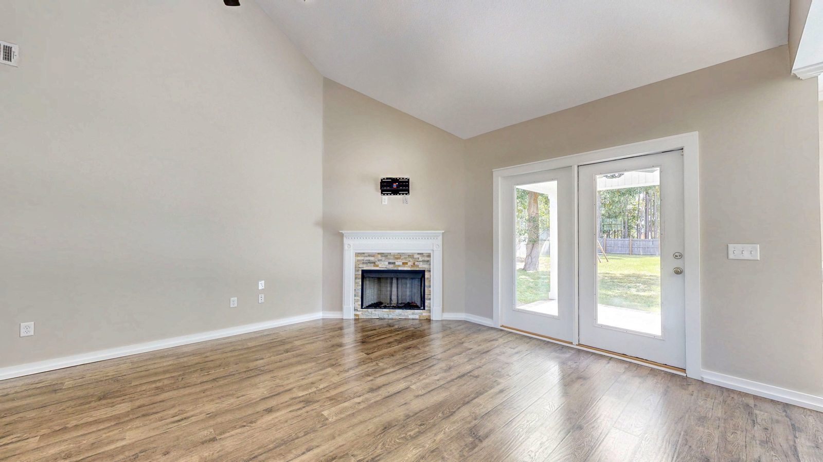 Vaulted great room with corner fireplace and French doors