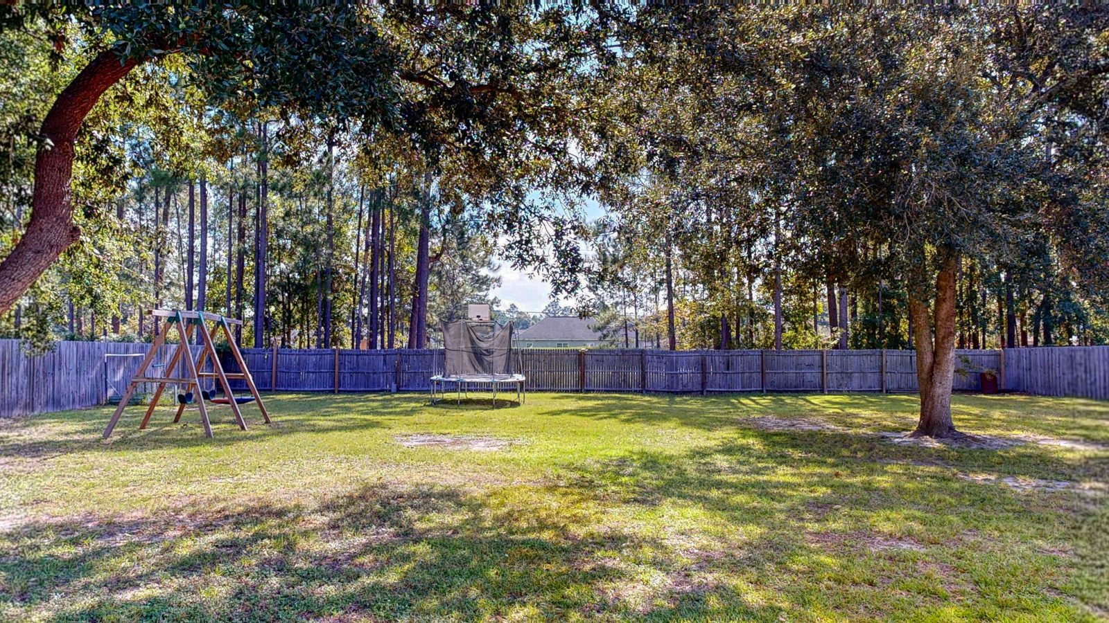 Privacy-fenced backyard with mature trees in the Village at Kingsley